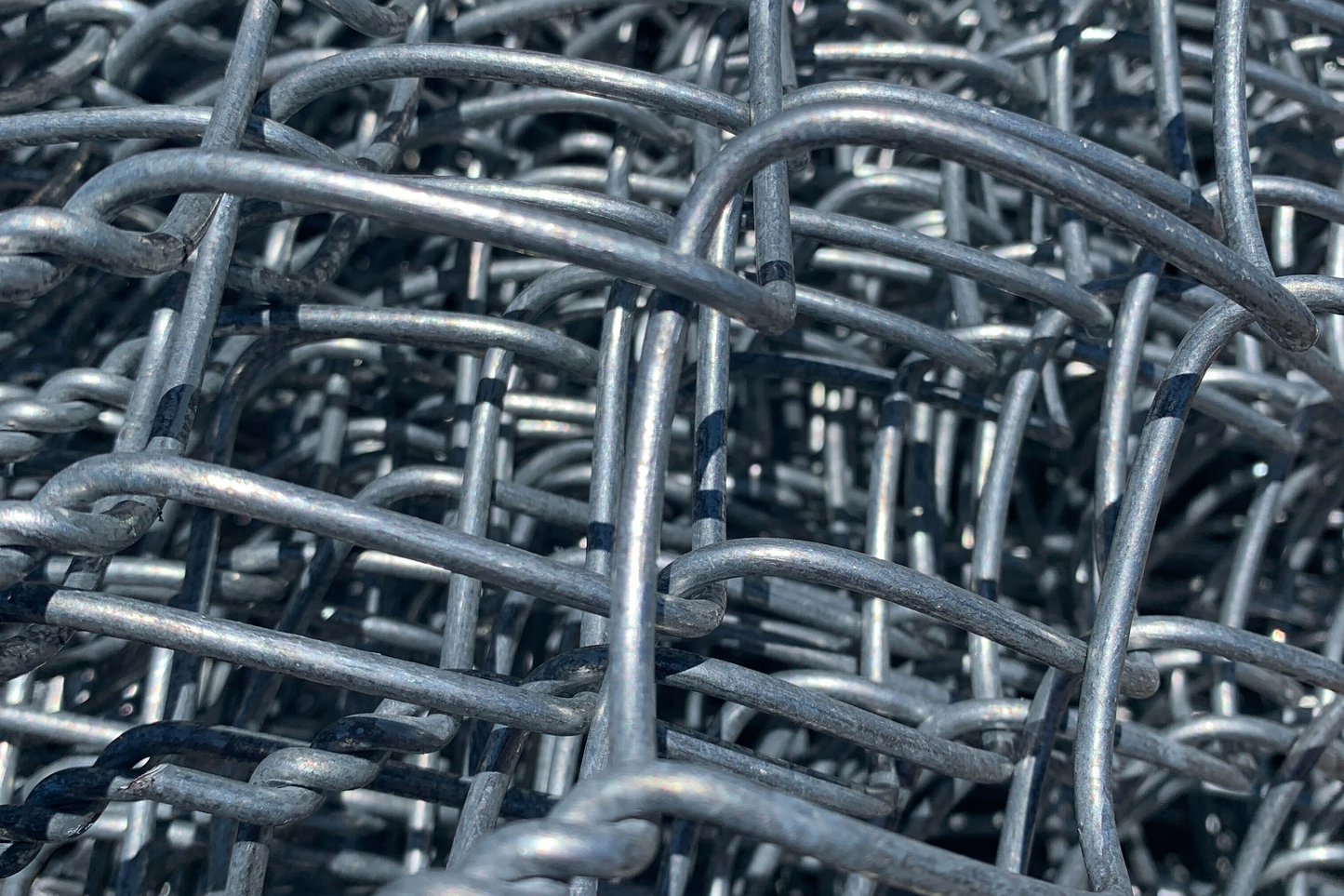 Close-up view of a section of 9 gauge galvanized chain link fence.