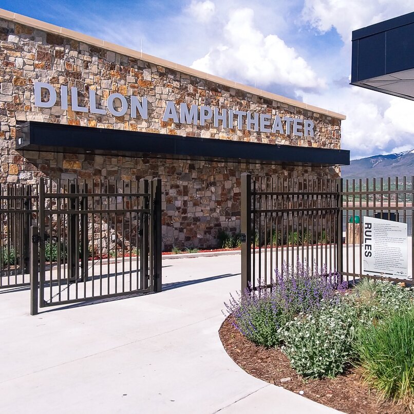 Extruded top flat bottom, three rail, brown ornamental fencing in front of a public amphitheater