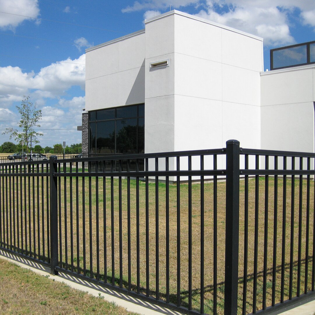 Flat top flat bottom, three rail fencing surrounding a office building