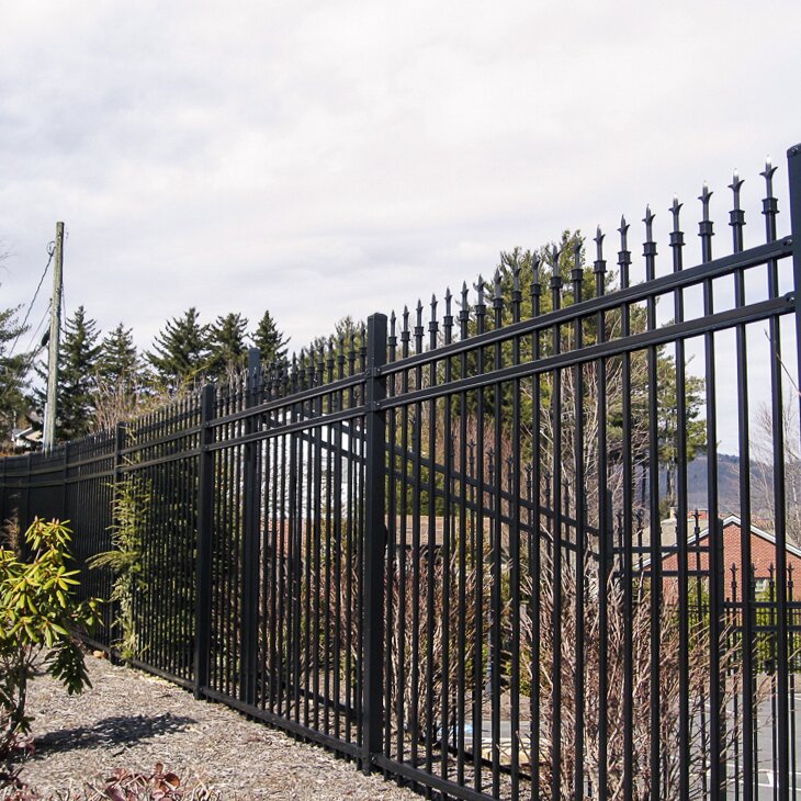 finial top extruded bottom, three rail, fencing with bushes in the background