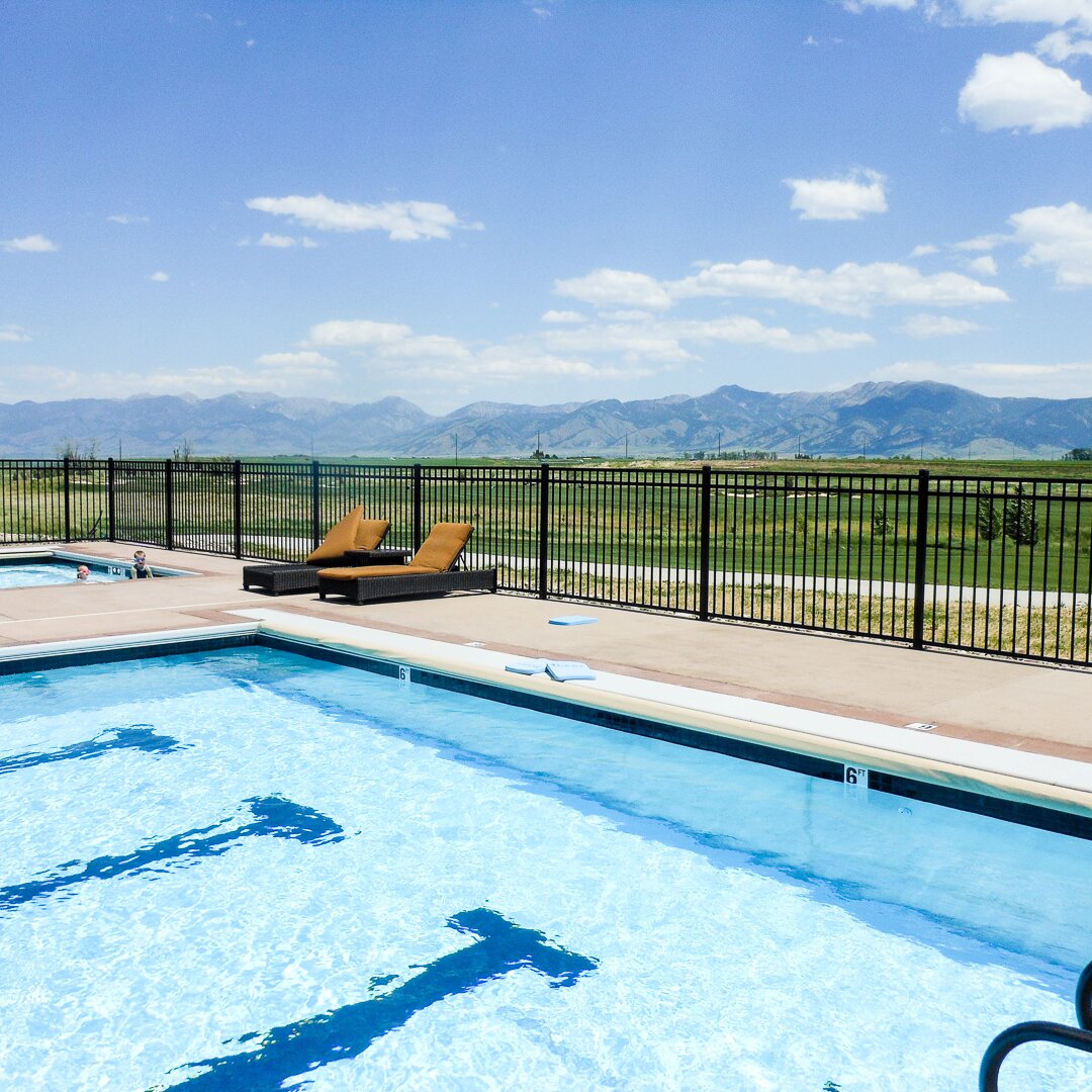 Flat top flat bottom, three rail fencing, separating a public pool from a golf course