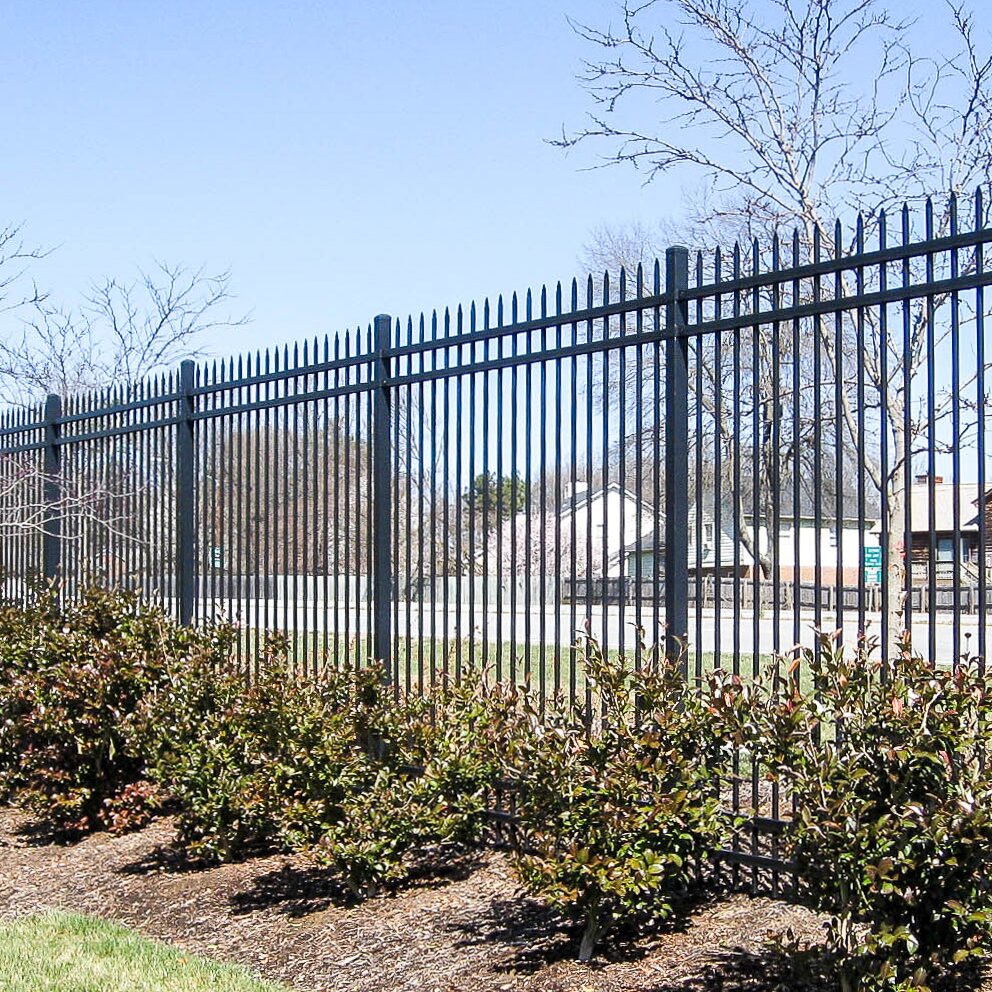 Pressed spear extruded bottom, four rail, commercial fencing surrounding a parking lot