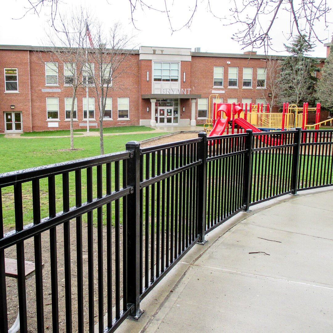 Flat top flat bottom, three rail fencing, around a playground at a public school