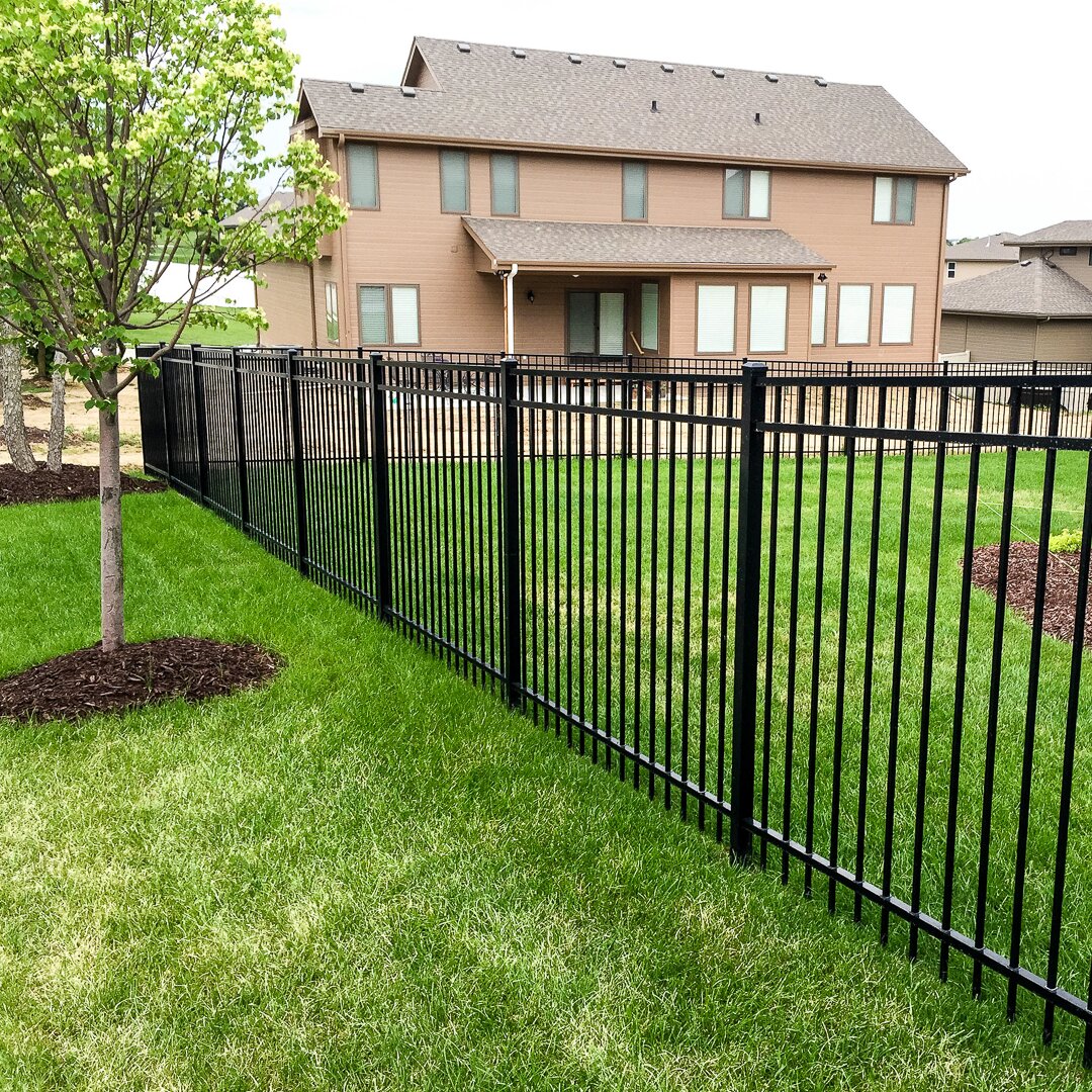 Flat top extruded bottom, three rail fencing surrounding a backyard